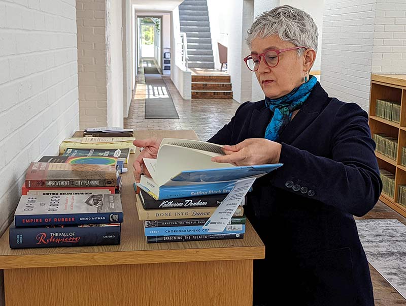 woman paging through a book at the library table