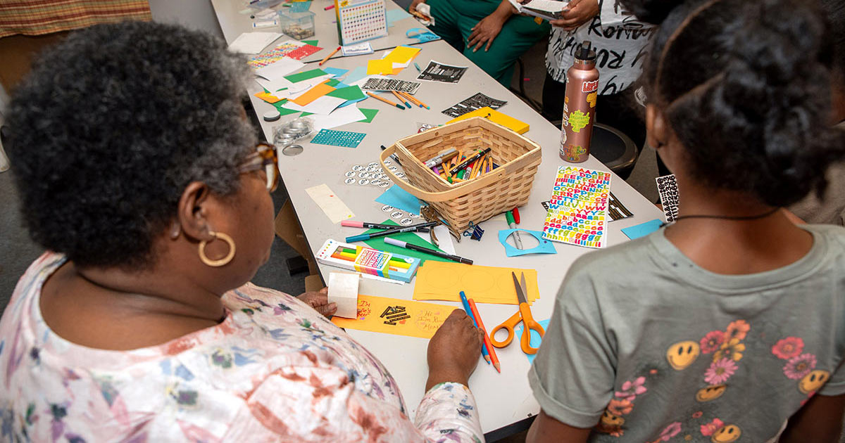 Festival participants of all ages craft buttons together and consider their role in the history of social movements.