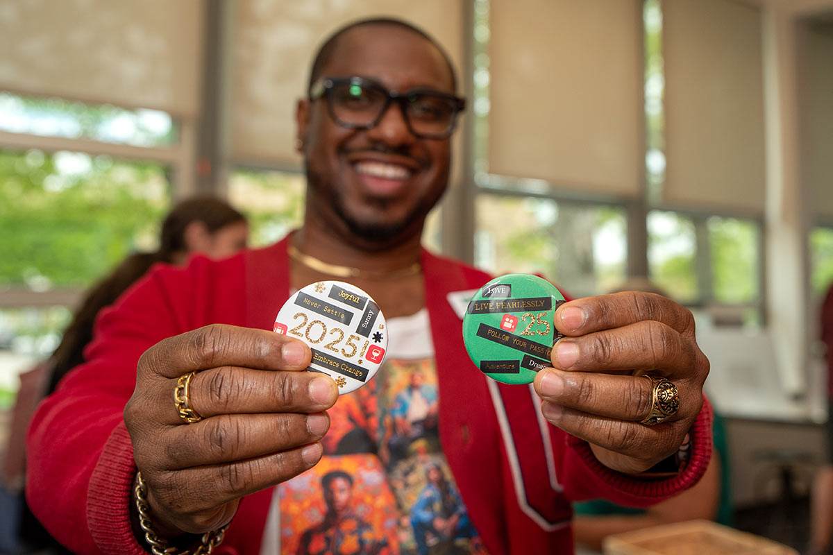 An event participant shows off their newly minted buttons! Photograph by Phillip Hamer.